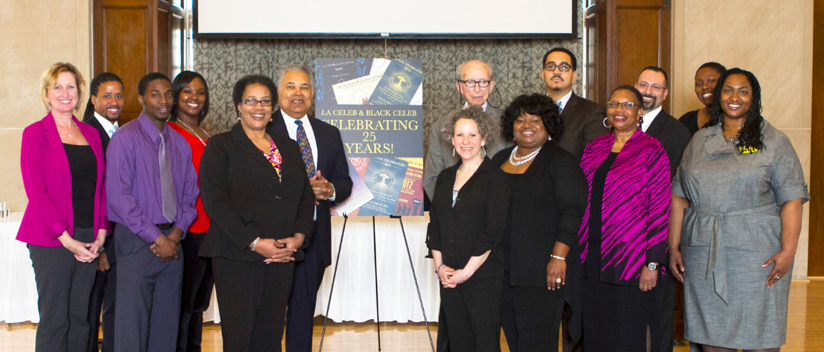 A group of people stand in front of a banner that reads 