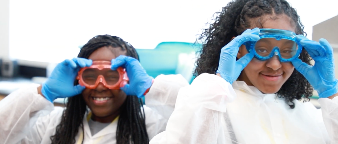 Wolverine Pathways students in a science class wearing blue goggles.
