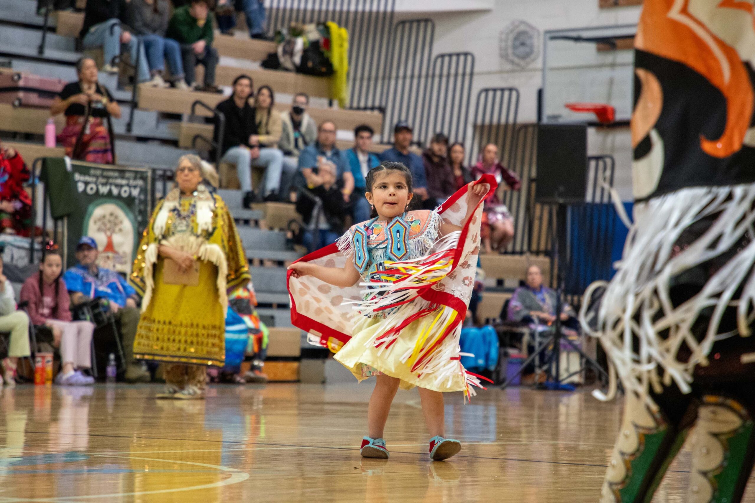 young child performing in regalia