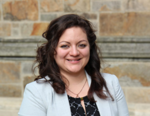headshot of Marissa Taylor wearing a white jacket against a stone wall